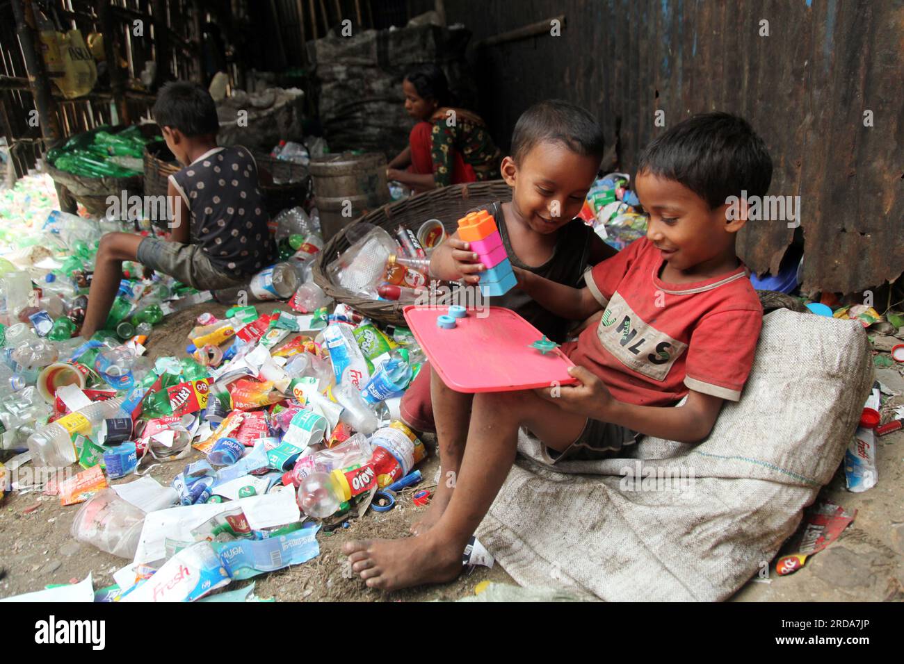 Dhaka, Dhaka, Bangladesh. 18 mars 2023. Les enfants jouent dans une usine de recyclage de bouteilles en plastique. la photo a été prise kmarangichar beribadgh. Nazmul i Banque D'Images