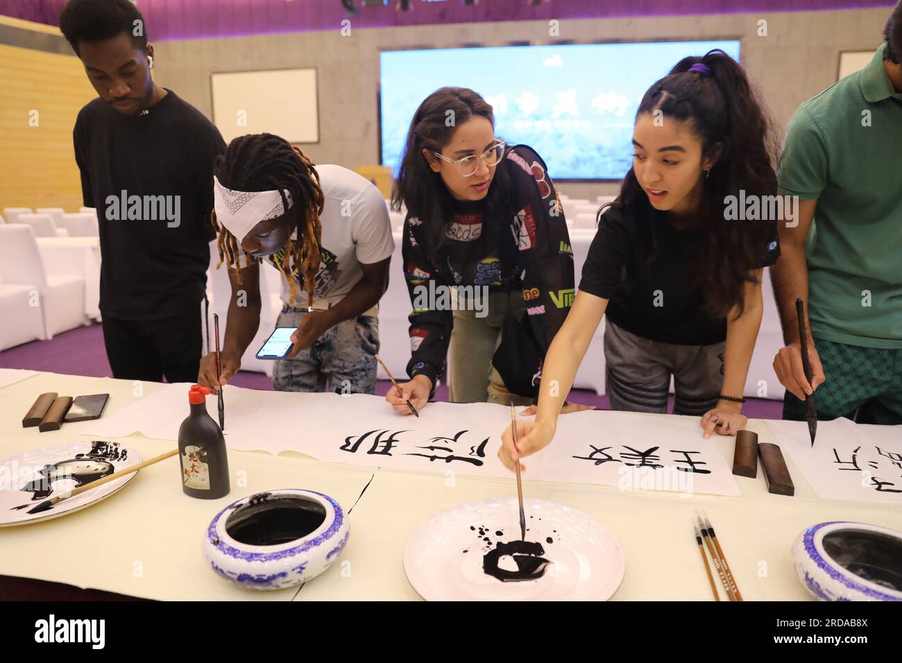 Les étudiants étrangers apprennent la calligraphie chinoise dans la ville de Linyi, dans la province du Shandong de l'est de la Chine, 18 juillet 2023. Banque D'Images