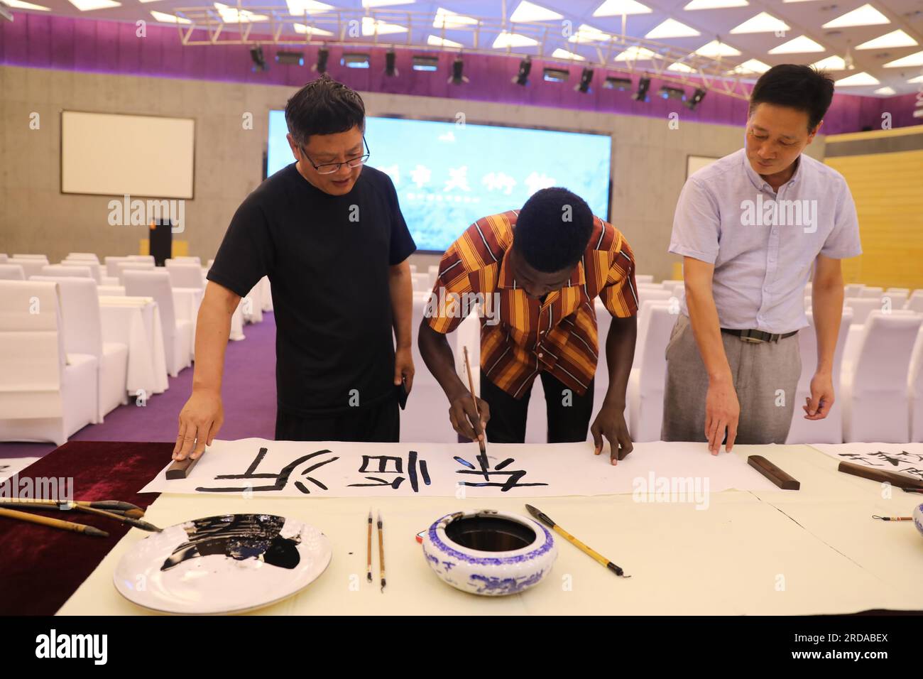 Les étudiants étrangers apprennent la calligraphie chinoise dans la ville de Linyi, dans la province du Shandong de l'est de la Chine, 18 juillet 2023. Banque D'Images