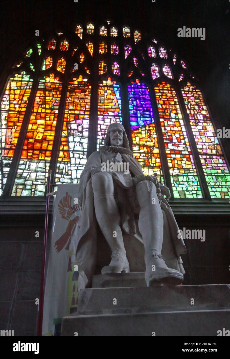 Statue victorienne Humphrey Chetham dans la cathédrale de Manchester, marchand à succès, devant un vitrail, Victoria St, Manchester, UK, M3 1SX Banque D'Images