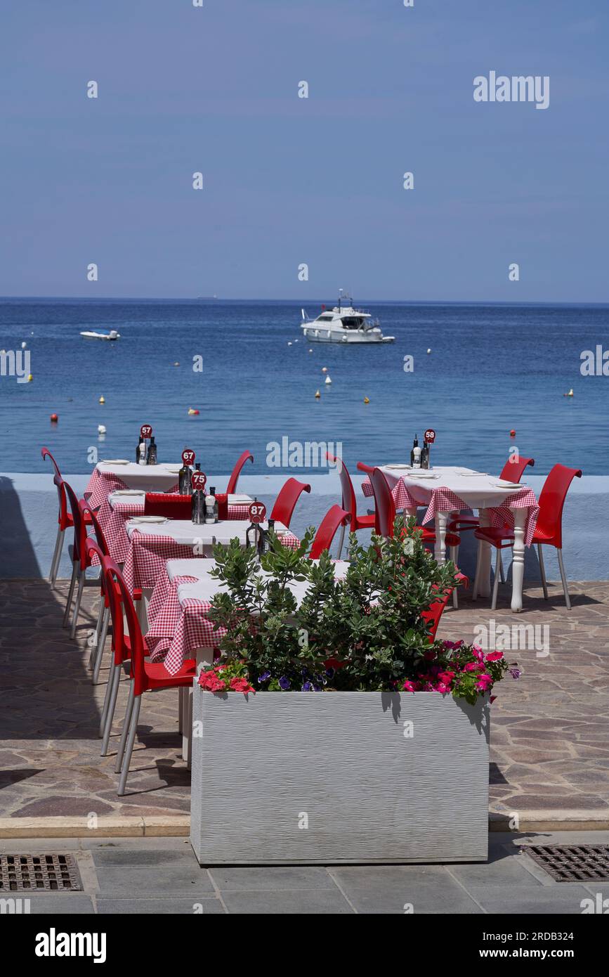 Tables et chaises de restaurant installées sur le front de mer de Marsalforn sur la côte de Gozo à Malte Banque D'Images