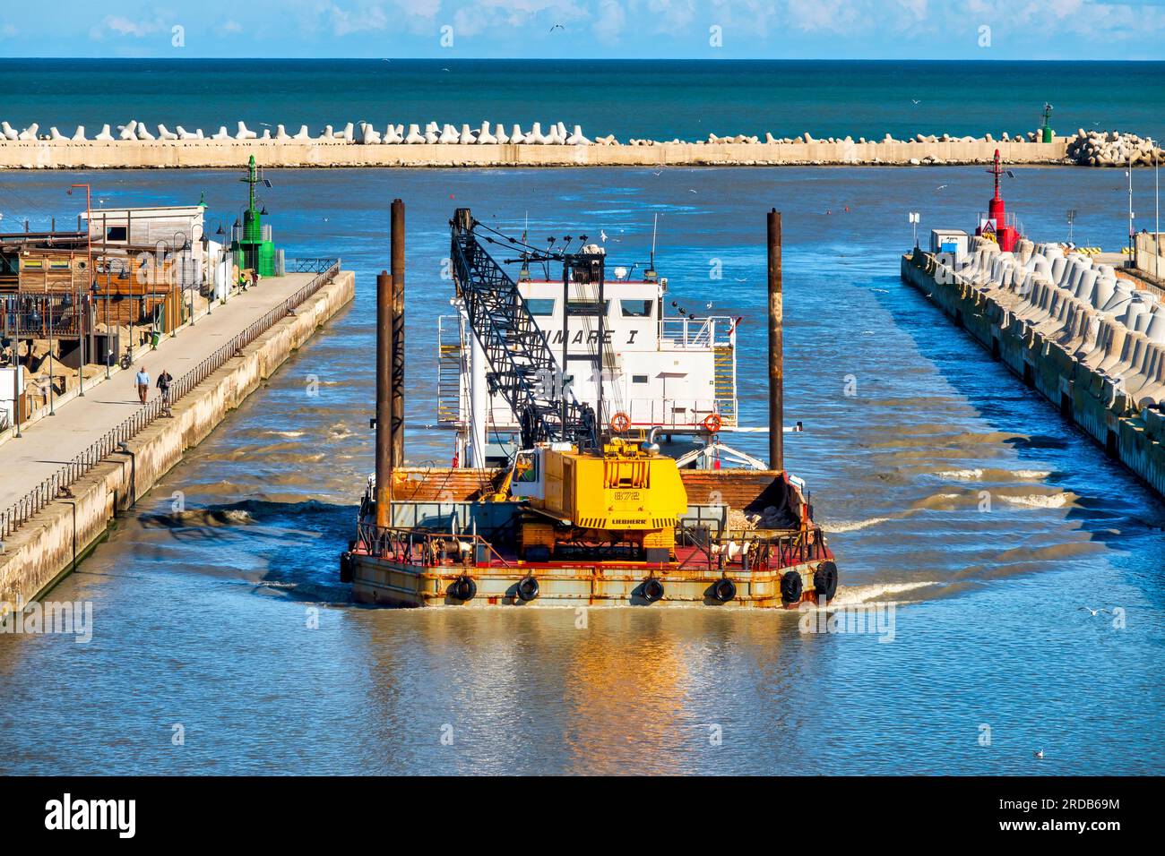 Transport bateau transportant une grue sur chenilles à l'embouchure de la rivière, Pescara, Italie Banque D'Images