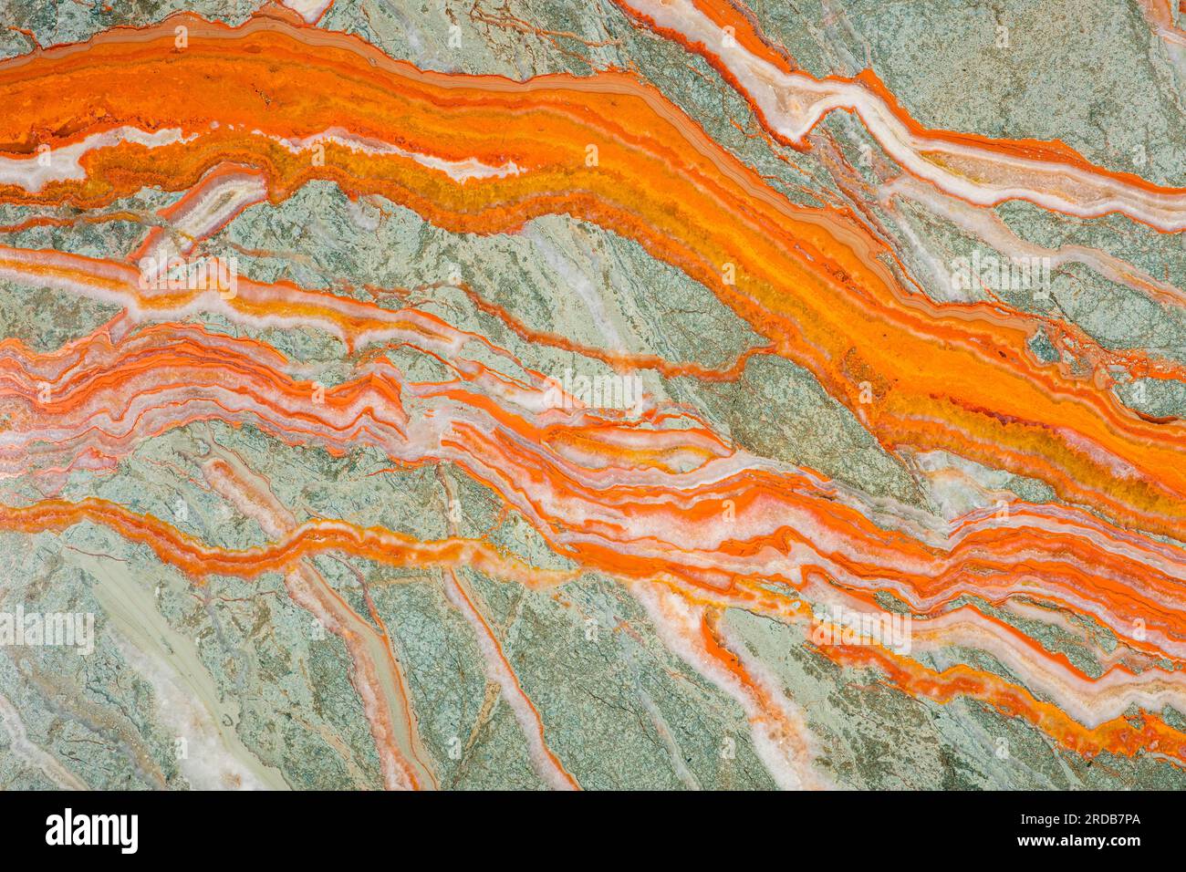 La texture unique de l'Onyx, des stries saturées lumineuses d'orange sur un fond gris-vert, semblables aux rivières Banque D'Images