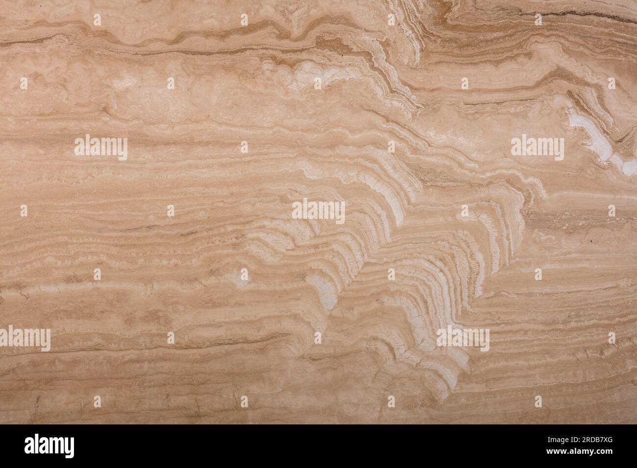 Texture unique de travertin naturel, motif doux de couches ondulées beiges et brunes. Banque D'Images
