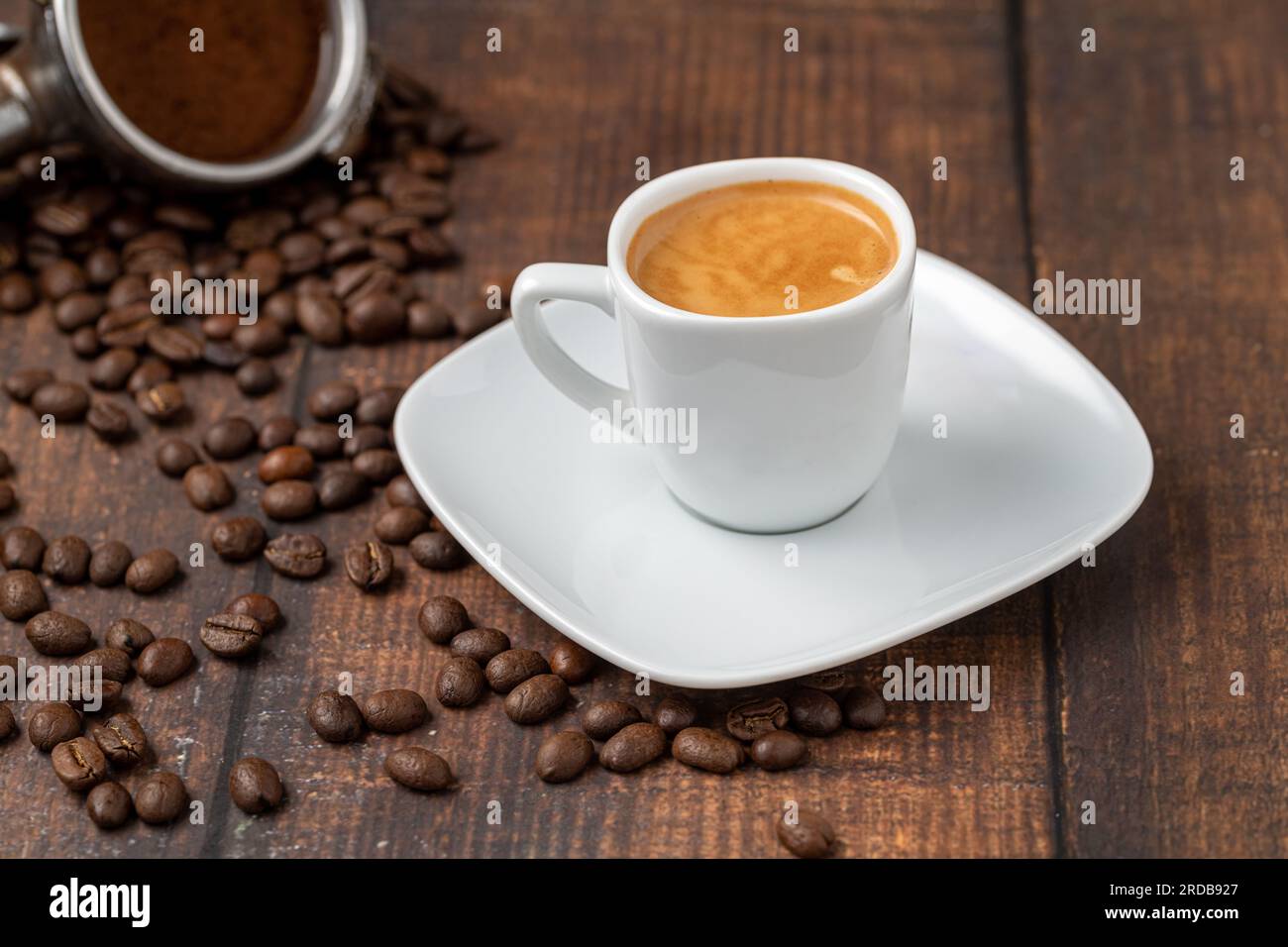 Café expresso frais et grains de café sur une table en bois Banque D'Images