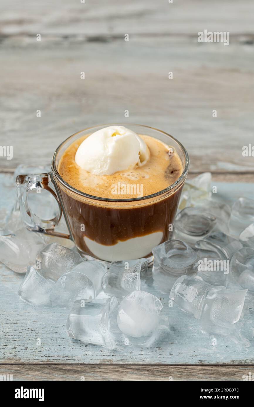 Café affogato avec de la crème glacée à la vanille dans une tasse en verre sur une table en bois Banque D'Images