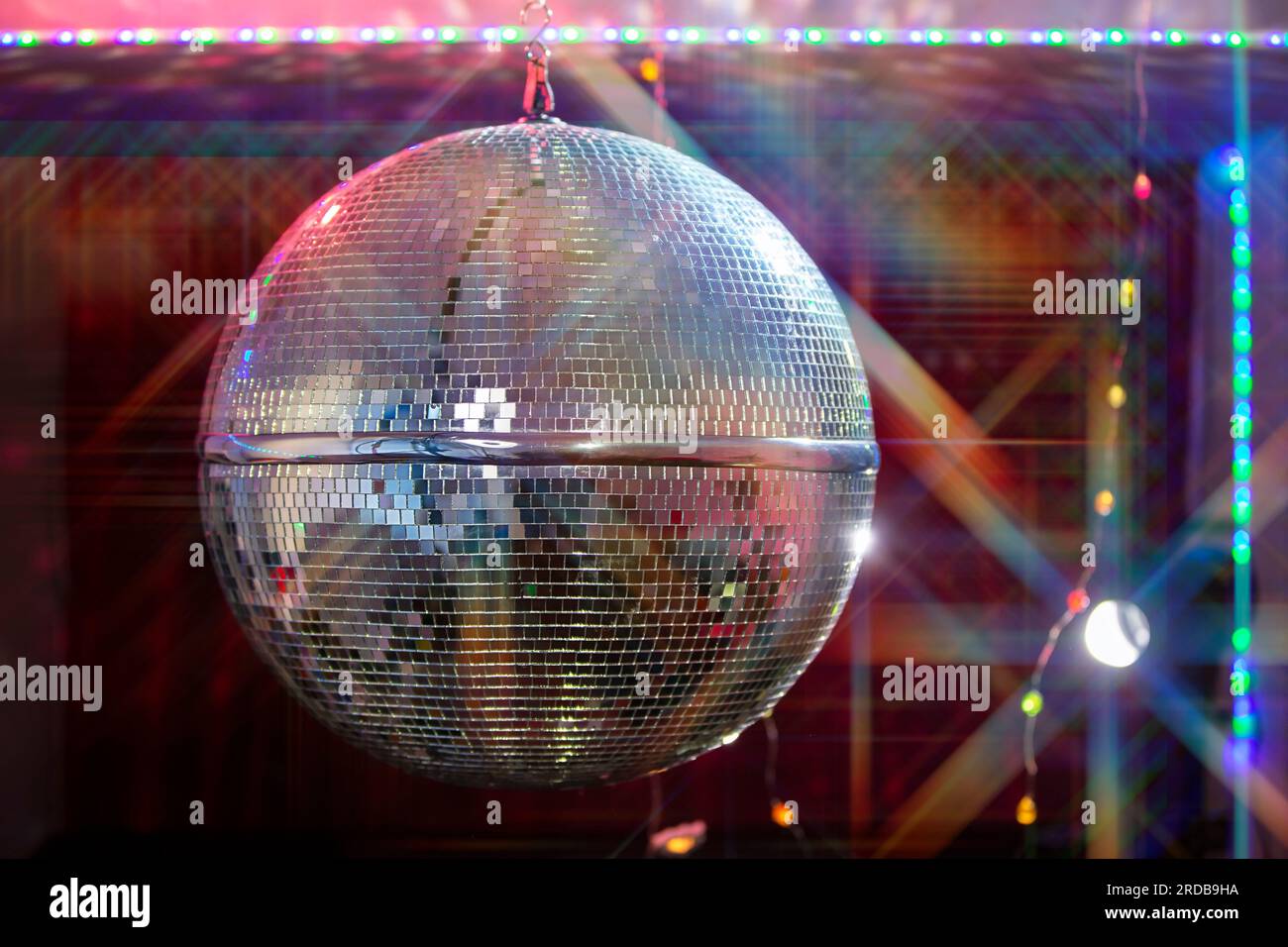 Boule disco avec des faisceaux lumineux, photo de fond de soirée. Banque D'Images