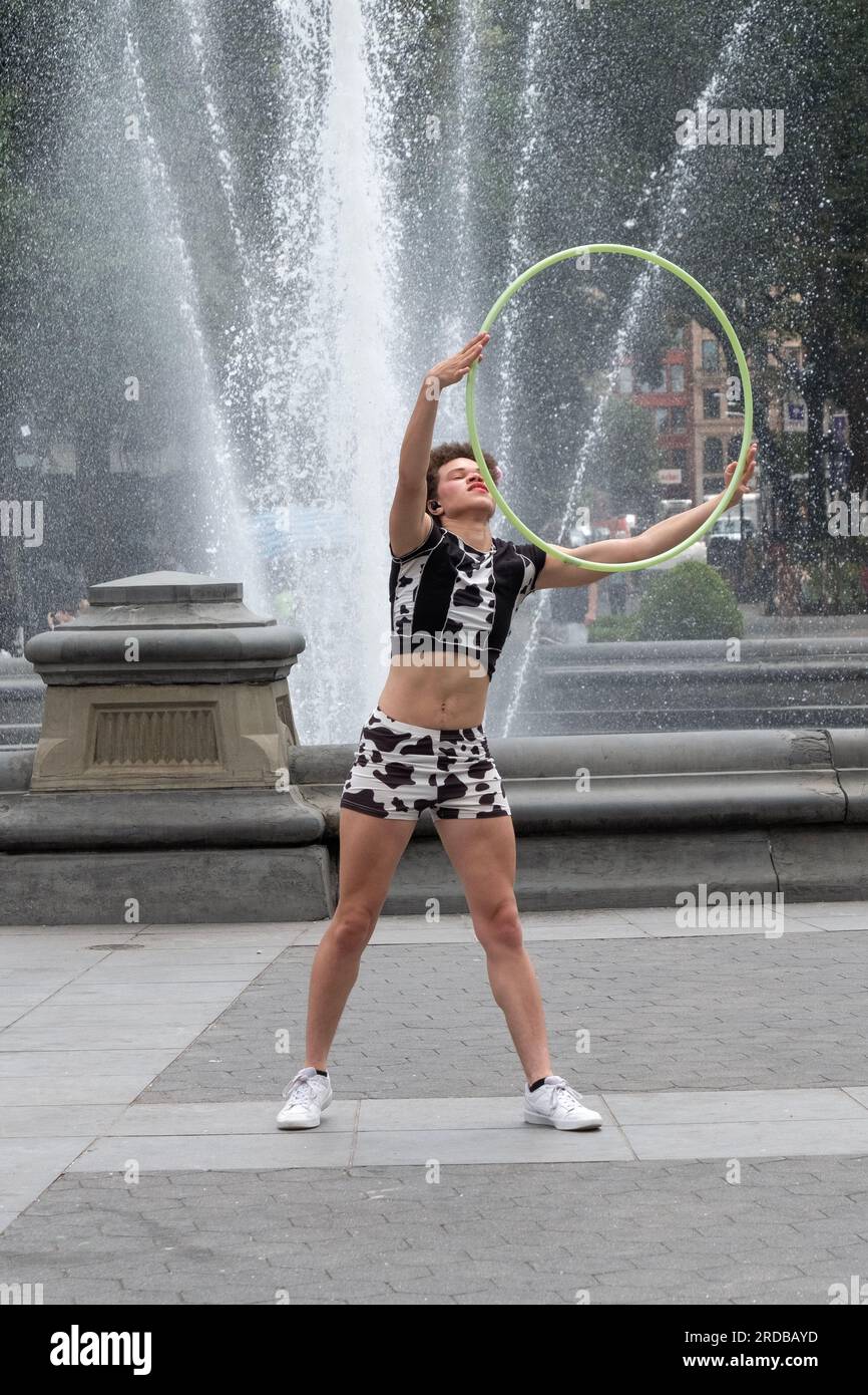 Une formidable artiste Hula Hoop fait son truc près de la fontaine dans Washington Square Park à Greenwich Village, Manhattan, New York. Banque D'Images