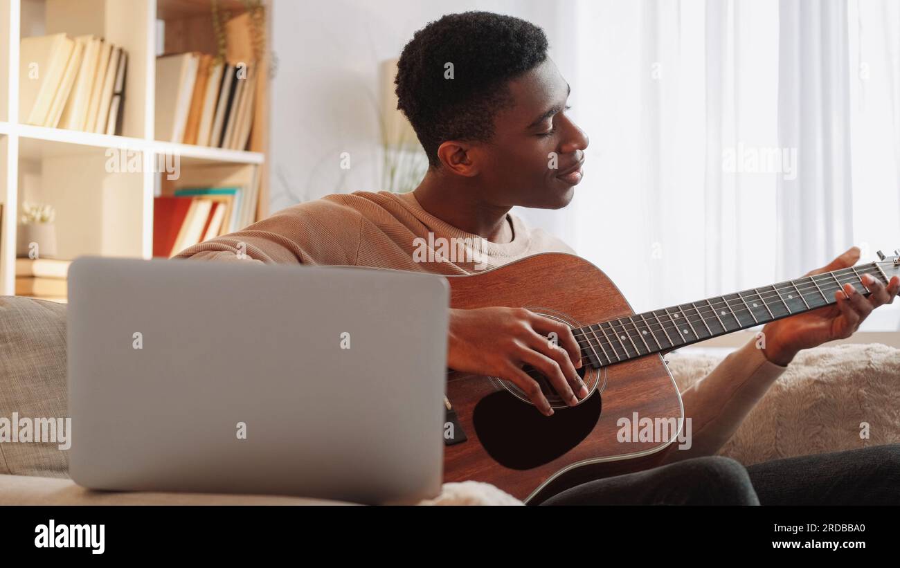 École de musique en ligne professeur de guitare homme ordinateur portable maison Banque D'Images