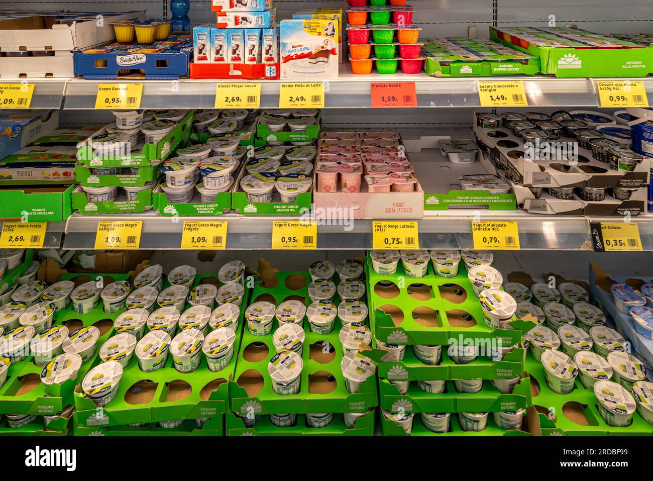 Italie - 19 juillet 2023 : yaourts de différentes saveurs en emballages de différentes marques présentés dans un comptoir réfrigéré à vendre dans un supermarché italien Banque D'Images