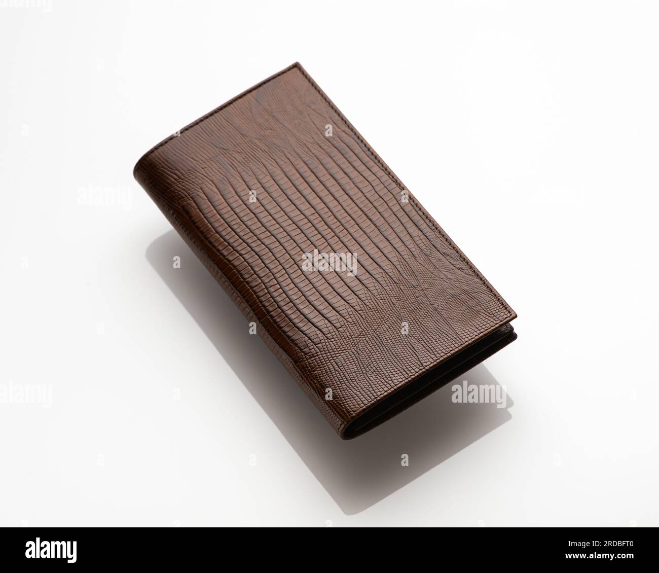 Gros plan d'un portefeuille pour homme en cuir à la mode sur un fond blanc avec reflet Banque D'Images