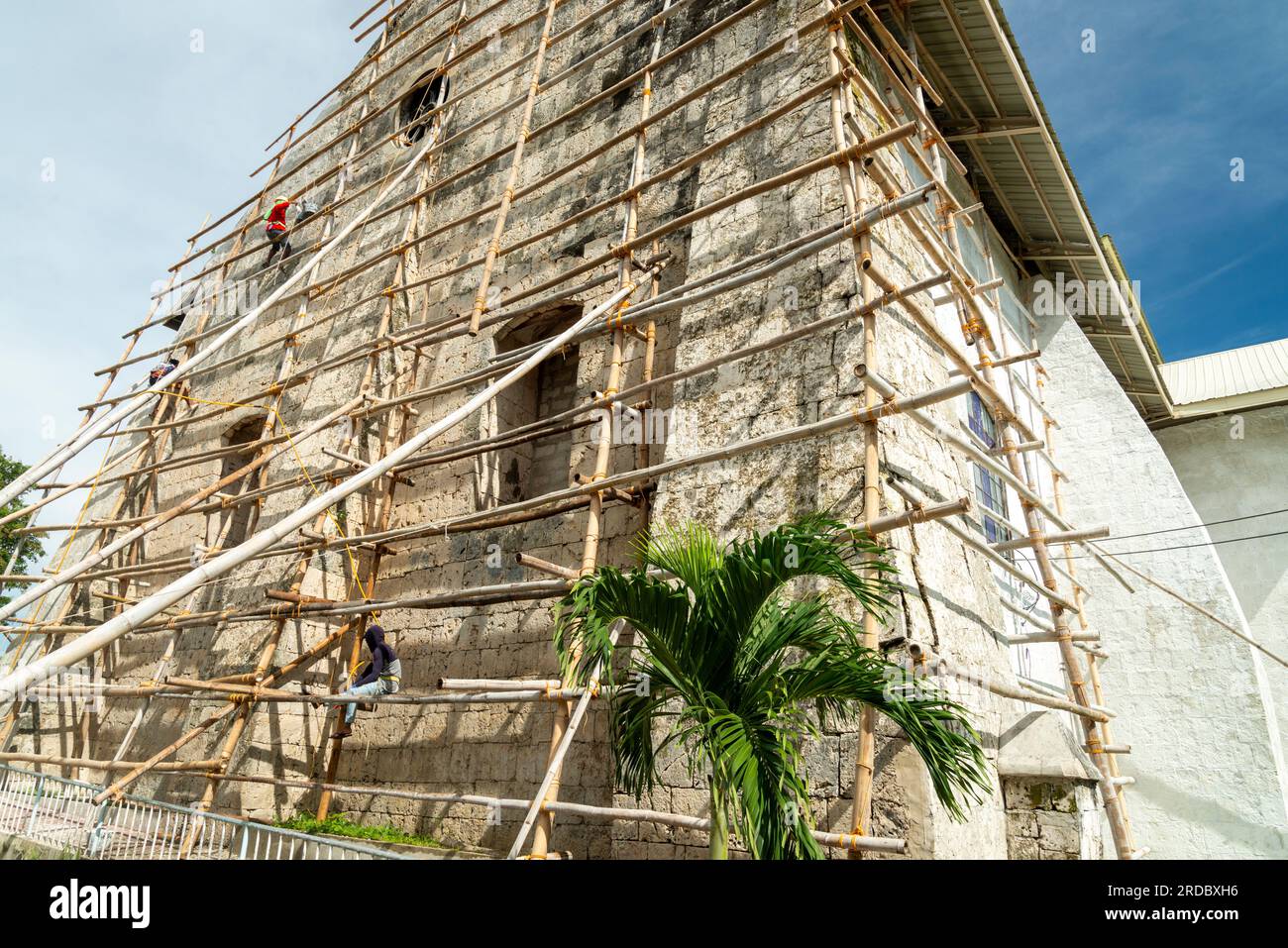 Île de Cebu, Philippines-27 janvier 2023 : utilisation précaire de poteaux de bambou comme cadre d'escalade, port de sable fin, les ouvriers se préparent à nouveau Banque D'Images