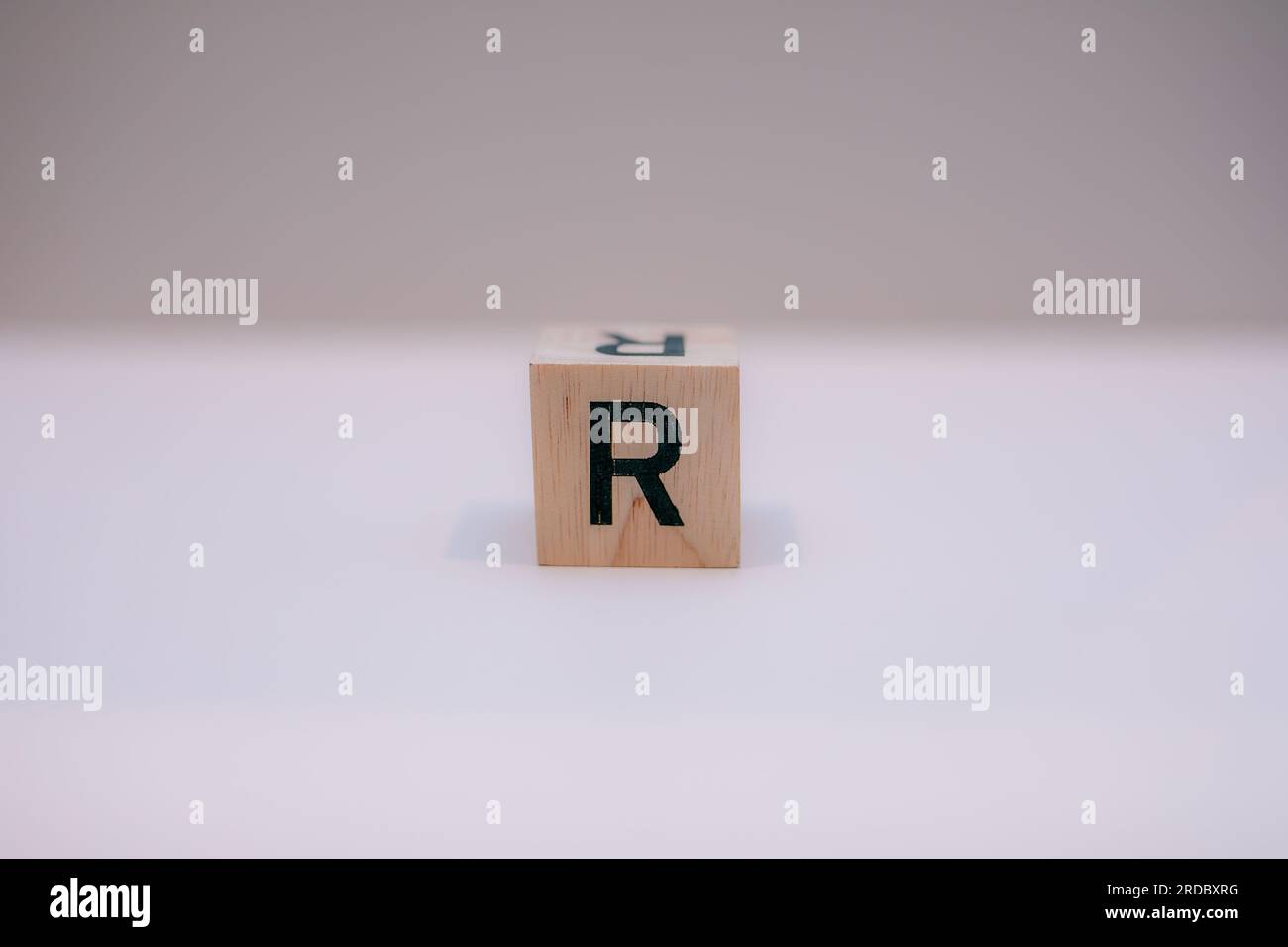 Bloc de bois écrit 'R' sur fond blanc. Banque D'Images