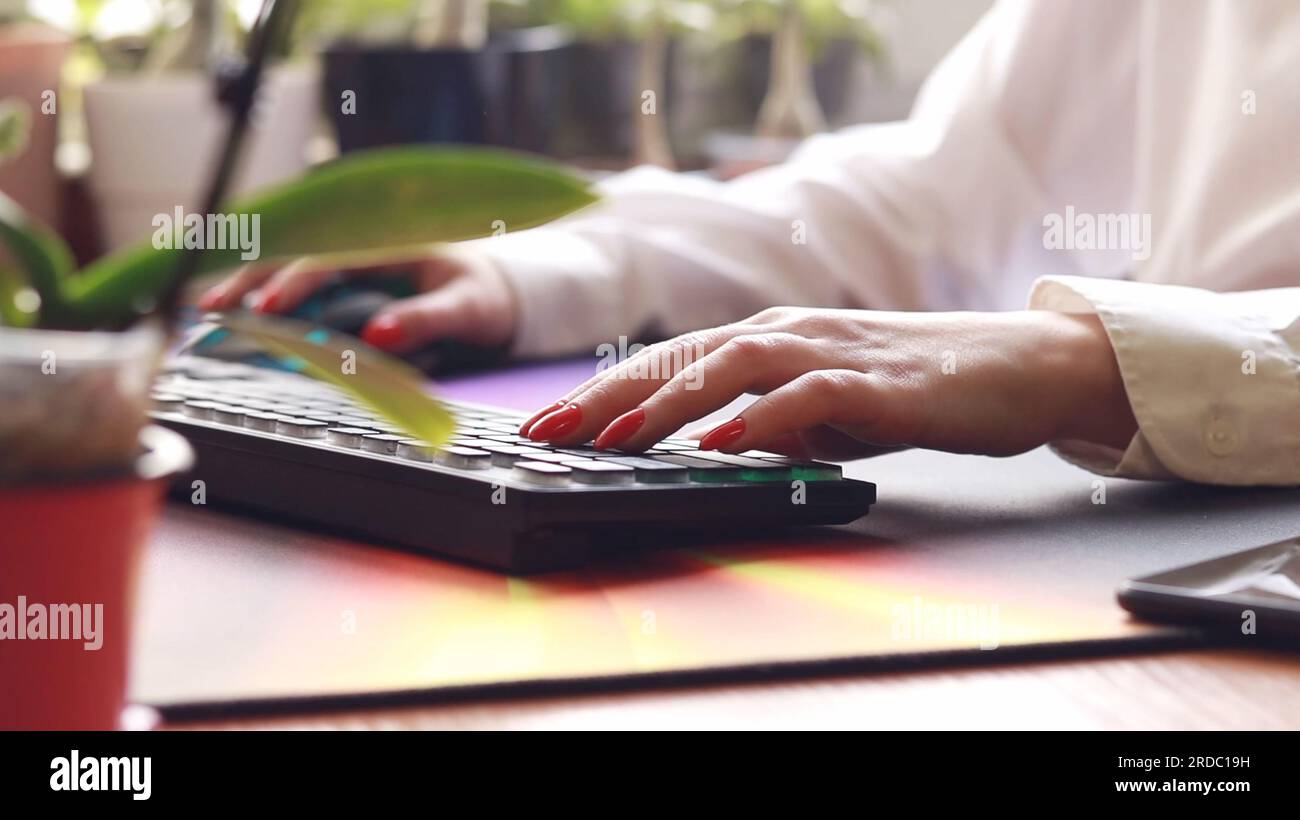 Mains sur le clavier en gros plan, bureau de travail travailler à distance de la maison. Femme blanche tapant sur le clavier. Enseignement à distance, éducation en ligne et travail sur co Banque D'Images