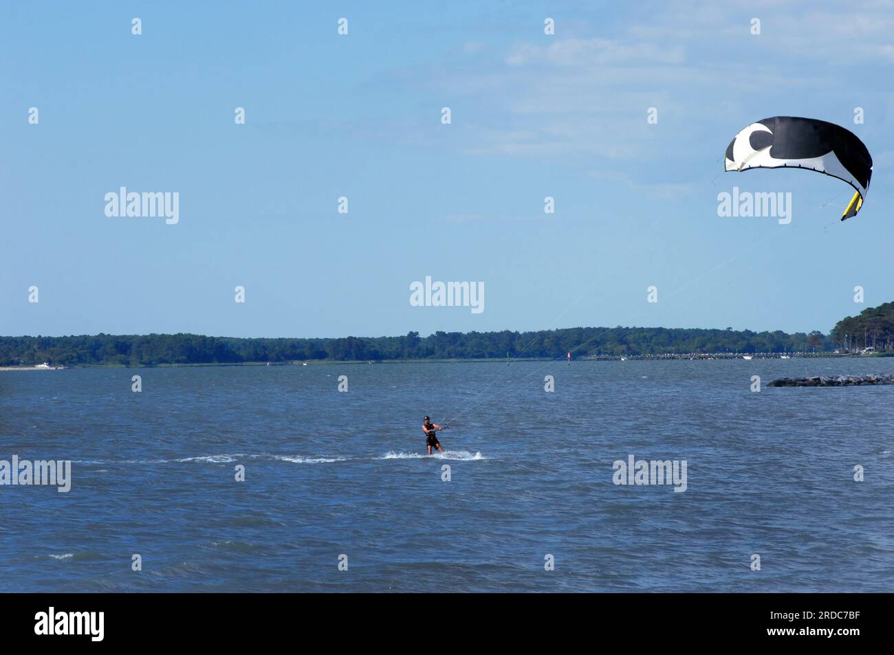 Kite surfeur skims à travers la baie de Chesapeake à Cape Charles, Virginia Beach. Kite est noir et blanc et exige une quantité extrême de forme physique pour cont Banque D'Images