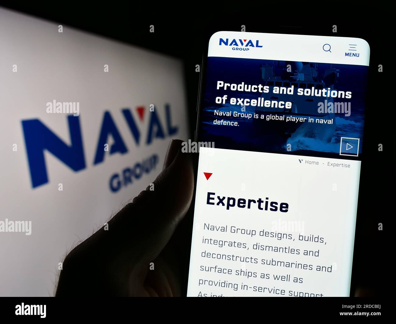 Personne tenant un téléphone portable avec la page Web de la société de défense française Naval Group S.A. sur l'écran devant le logo. Concentrez-vous sur le centre de l'écran du téléphone. Banque D'Images