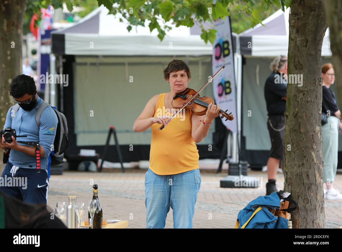 Londres, Royaume-Uni. 20 juillet 2023. 'Bench invasion' de la Compagnie Krak. Dans la performance 'Bench invasion', l'artiste belge Dieter Peter Raphaël Missiaen se déplace dans l'espace public avec dix personnes locales, chacune avec un banc sous le bras, à la recherche de contacts. À un moment inopiné, ils installent des bancs et invitent activement les gens à s’asseoir devant eux. De cette façon, il (re)connecte les gens. Le Festival d'ensemble est un festival de quatre jours de théâtre, de cirque, de danse, de musique et d'art numérique gratuits au Royal Victoria Dock. Ensemble Festival explore les thèmes de l'écologie, de la vie moderne et de la reconnexion, et comprend deux jours de pop-up per Banque D'Images
