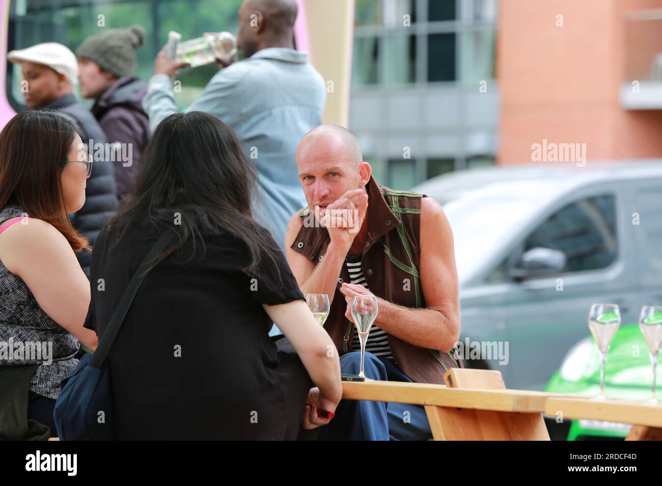 Londres, Royaume-Uni. 20 juillet 2023. 'Bench invasion' de la Compagnie Krak. Dans la performance 'Bench invasion', l'artiste belge Dieter Peter Raphaël Missiaen se déplace dans l'espace public avec dix personnes locales, chacune avec un banc sous le bras, à la recherche de contacts. À un moment inopiné, ils installent des bancs et invitent activement les gens à s’asseoir devant eux. De cette façon, il (re)connecte les gens. Le Festival d'ensemble est un festival de quatre jours de théâtre, de cirque, de danse, de musique et d'art numérique gratuits au Royal Victoria Dock. Ensemble Festival explore les thèmes de l'écologie, de la vie moderne et de la reconnexion, et comprend deux jours de pop-up per Banque D'Images