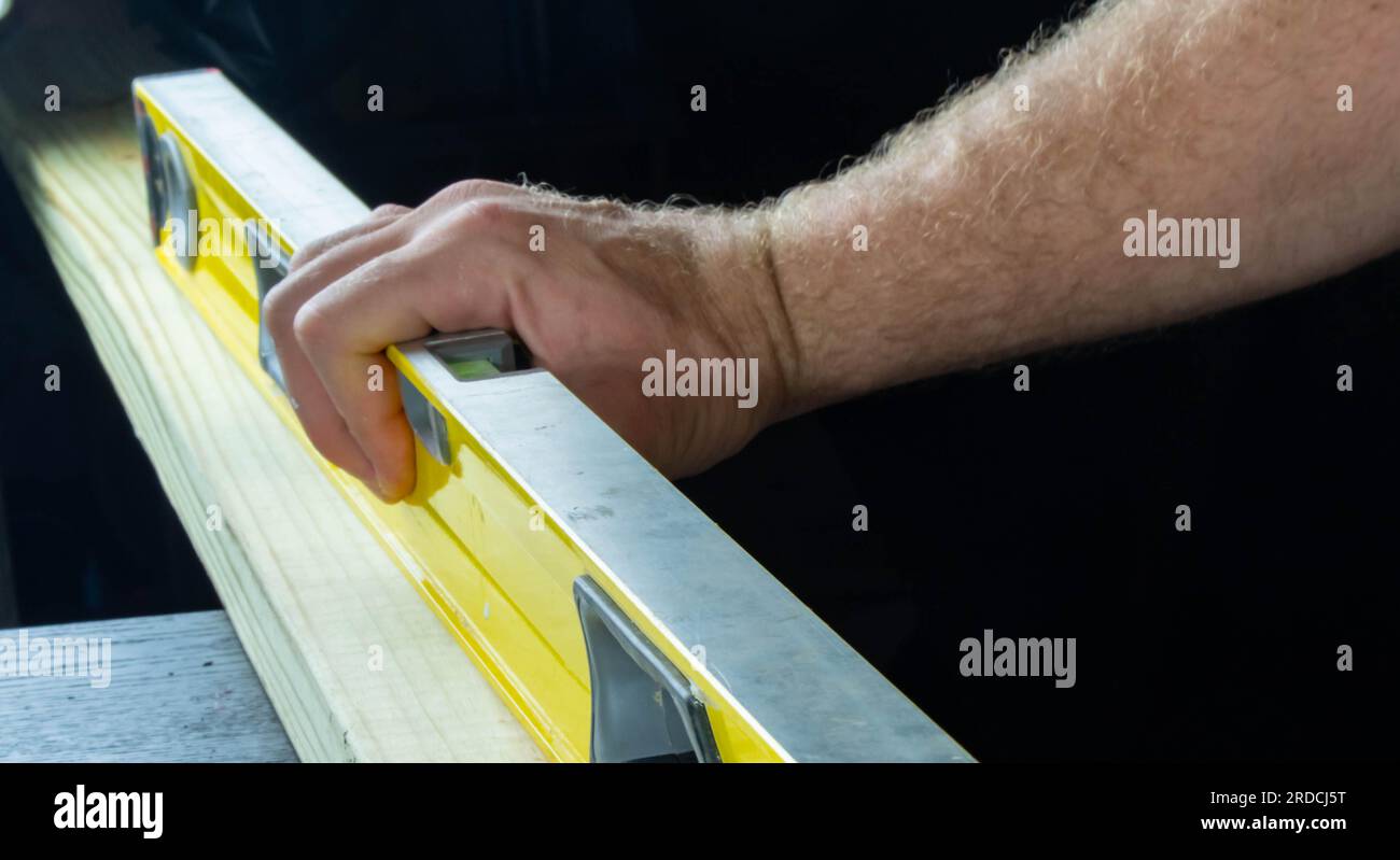 Niveau de construction isolé sur fond sombre tenu à la main arrière-plans de conception graphique Banque D'Images