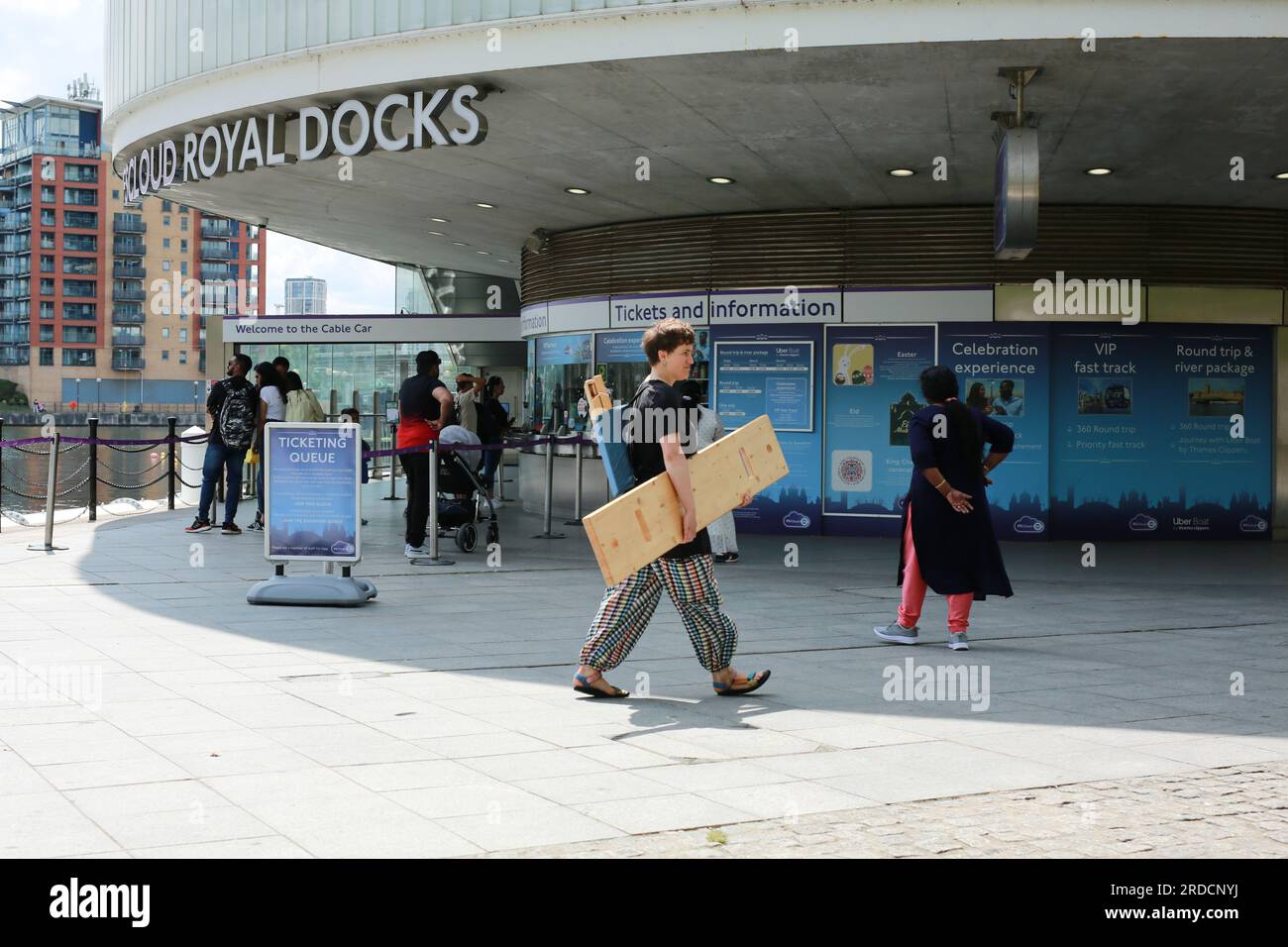 Londres, Royaume-Uni. 20 juillet 2023. 'Bench invasion' de la Compagnie Krak. Dans la performance 'Bench invasion', l'artiste belge Dieter Peter Raphaël Missiaen se déplace dans l'espace public avec dix personnes locales, chacune avec un banc sous le bras, à la recherche de contacts. À un moment inopiné, ils installent des bancs et invitent activement les gens à s’asseoir devant eux. De cette façon, il (re)connecte les gens. Le Festival d'ensemble est un festival de quatre jours de théâtre, de cirque, de danse, de musique et d'art numérique gratuits au Royal Victoria Dock. Ensemble Festival explore les thèmes de l'écologie, de la vie moderne et de la reconnexion, et comprend deux jours de pop-up per Banque D'Images