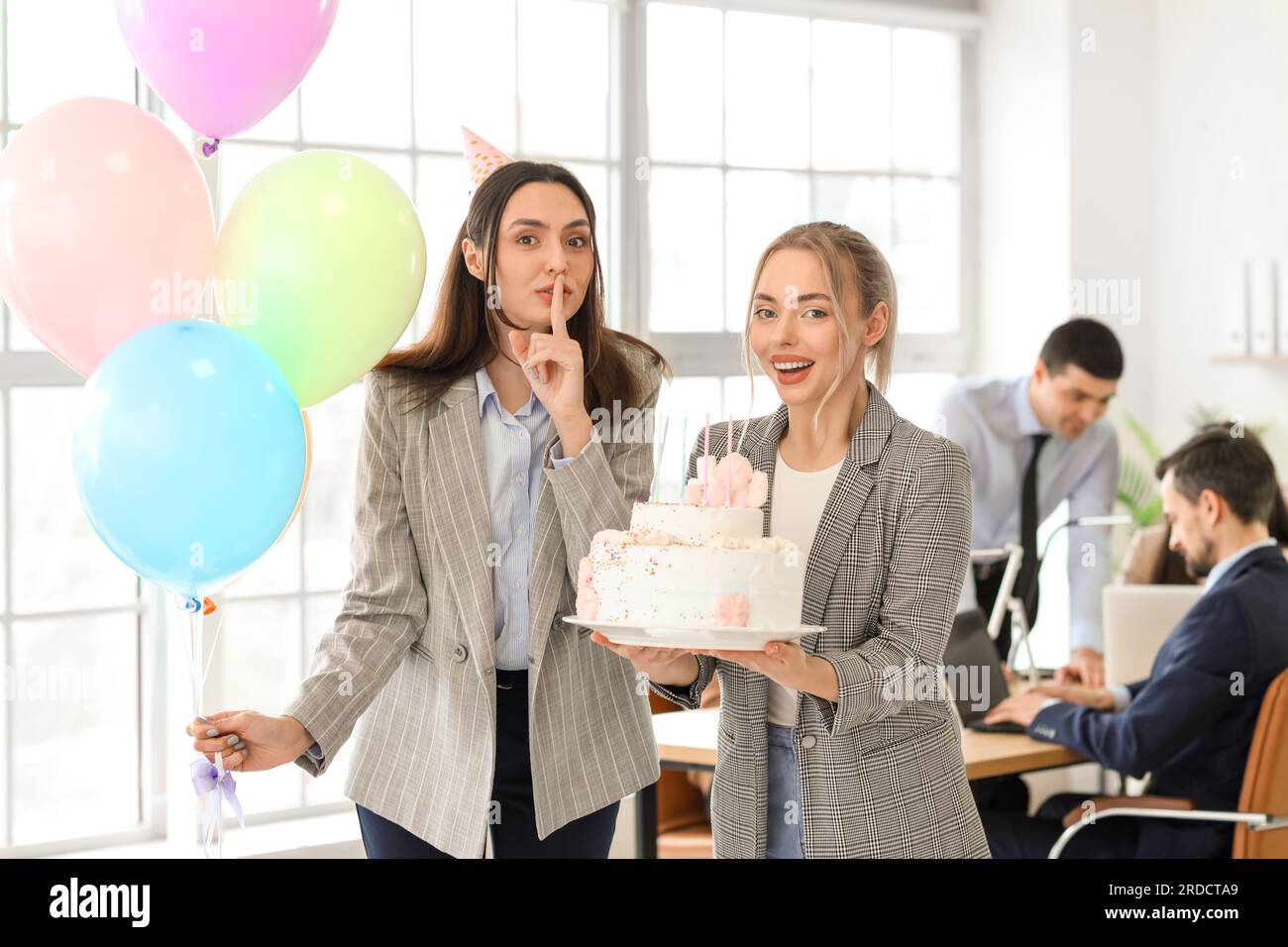 Collègues femmes avec gâteau d'anniversaire à la fête dans le bureau Banque D'Images