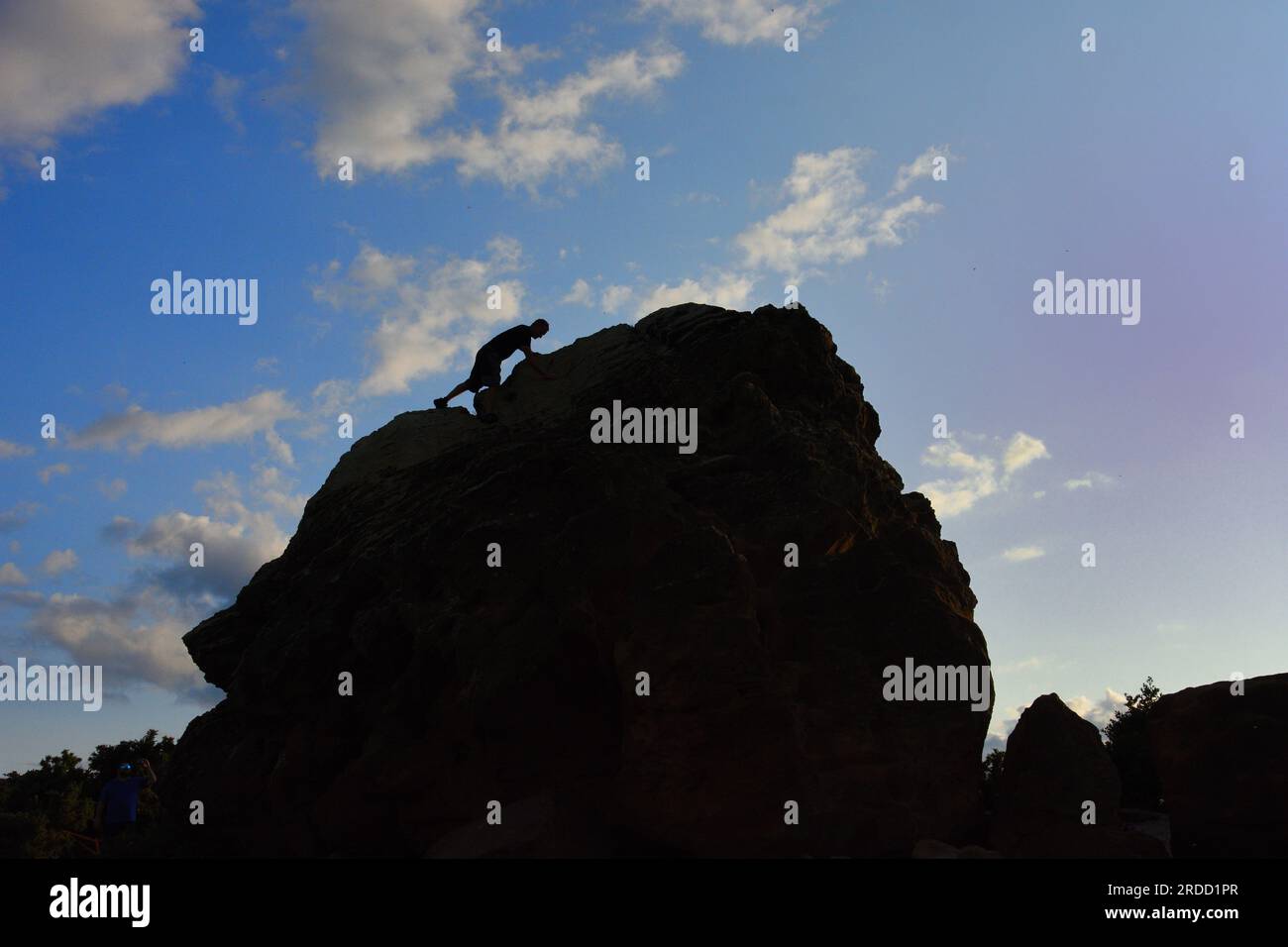 Silhouette d'un jeune grimpeur sur Agglestone Rock dans le Dorset Banque D'Images