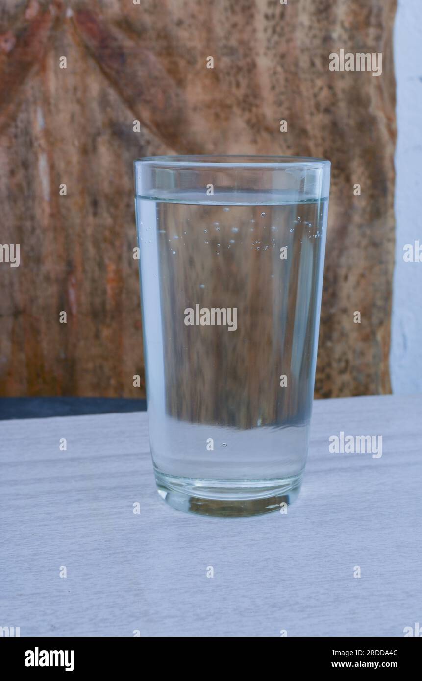 Gros plan d'un verre d'eau pure sur une table, illustrant l'harmonie entre la santé personnelle et la préservation de l'environnement. Banque D'Images