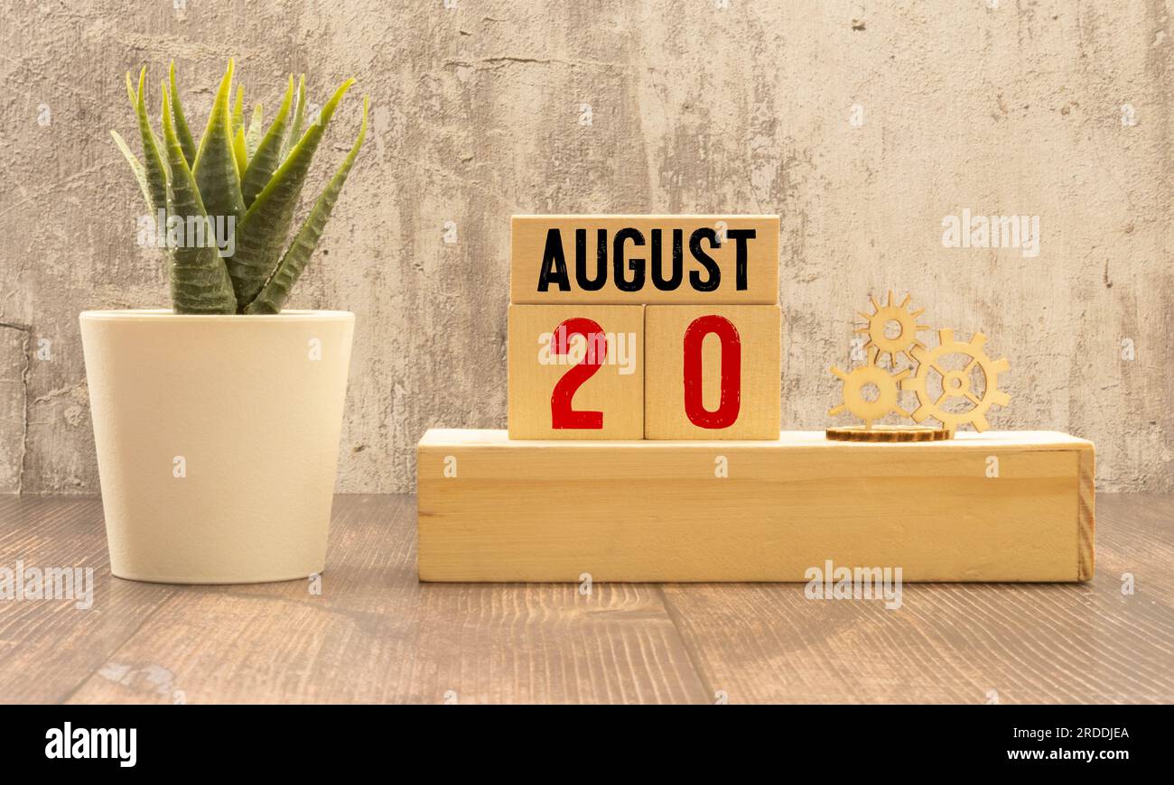 20 août. Août 20 calendrier cube en bois avec des objets flous sur fond. Banque D'Images