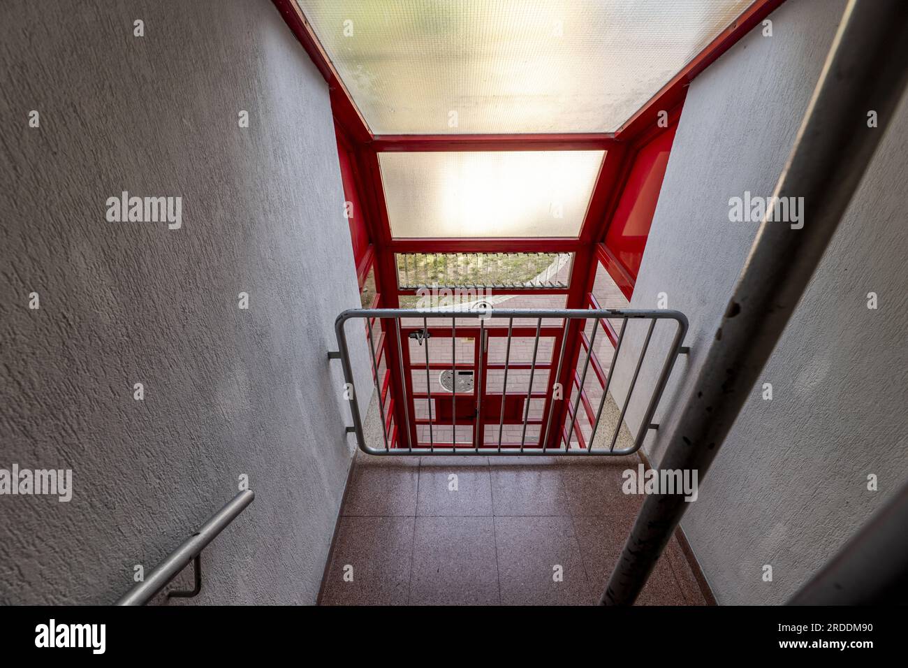 Volées d'escaliers avec balustrades en fer peint gris et planchers en terrazzo rouge Banque D'Images