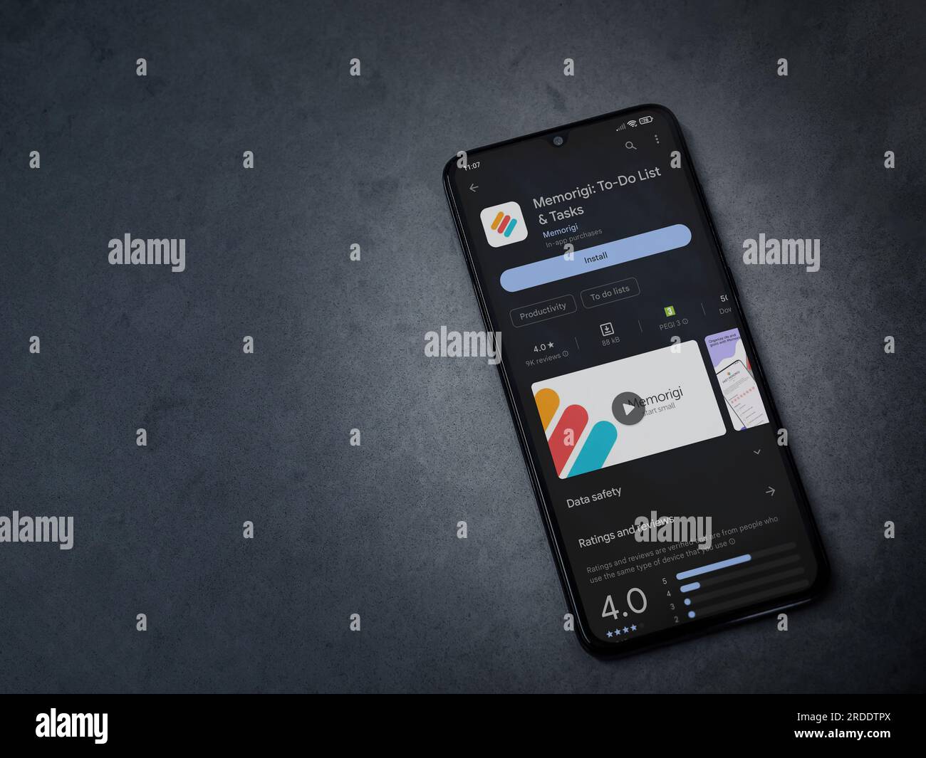 LOD, Israël - 16 juillet 2023 : page Memorigi app play store sur smartphone sur fond de pierre de marbre foncé. Vue de dessus à plat avec espace de copie. Banque D'Images