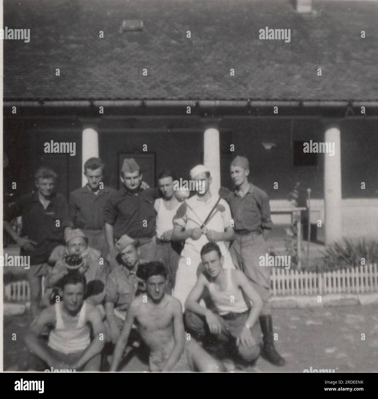 Photo de groupe du personnel de cuisine militaire vintage de la Seconde Guerre mondiale ( WW2) le chef cuisinier tient ses cuillères même pour la photographie et il porte son propre uniforme de chef dans la caserne militaire. sa zone de guerre est la cuisine car il devait nourrir les troupes affamées. Banque D'Images