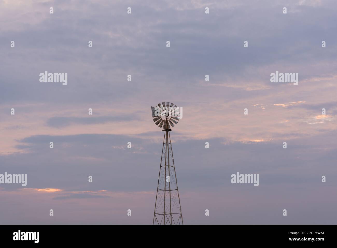 Un moulin à vent centré contre le coucher du soleil Banque D'Images