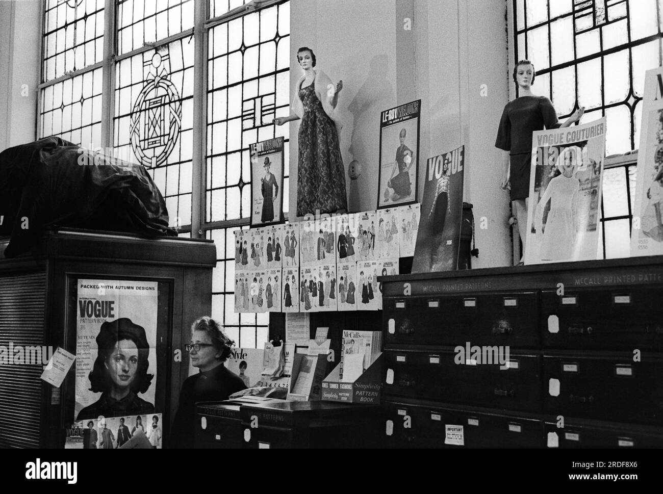 Derry et Toms le grand magasin de Kensington High Street. Département de patrons de confection de vêtements. Une femme assistante de magasin debout derrière un comptoir. Londres, Angleterre vers 1968. ANNÉES 1960 ROYAUME-UNI HOMER SYKES Banque D'Images