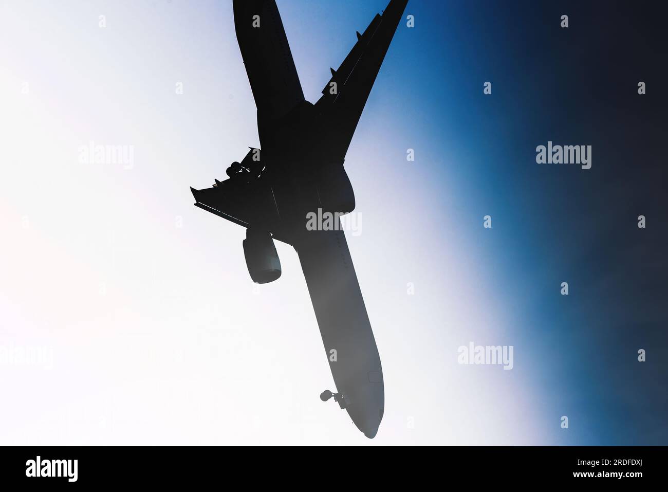 Silhouette d'un grand avion s'écrasant avec le nez plongeant au sol contre le ciel bleu Banque D'Images