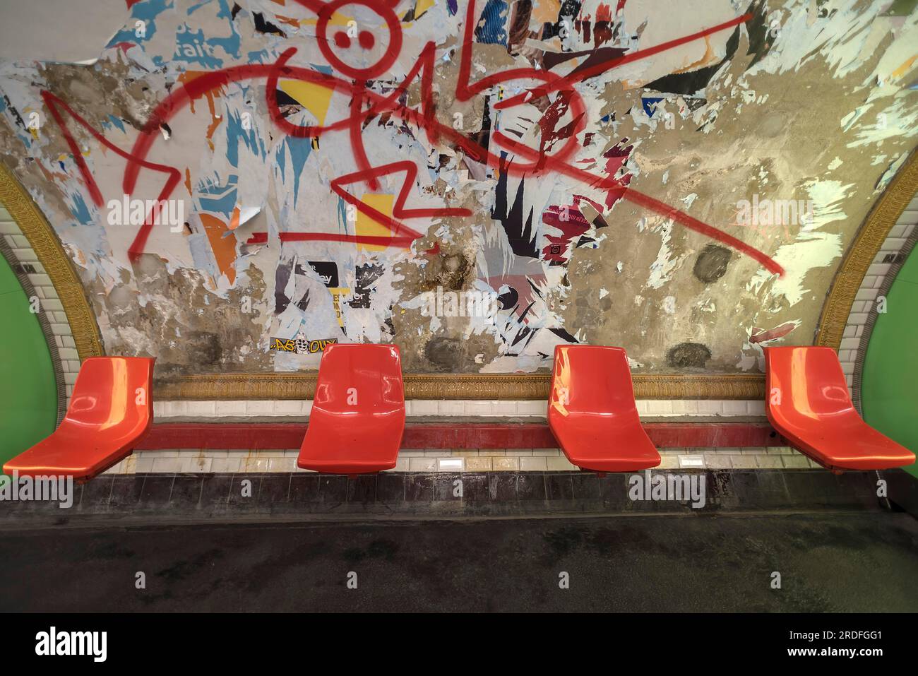 Sièges rouges dans le métro devant un panneau d'affichage démoli, Paris, France, délabré, graffiti Banque D'Images