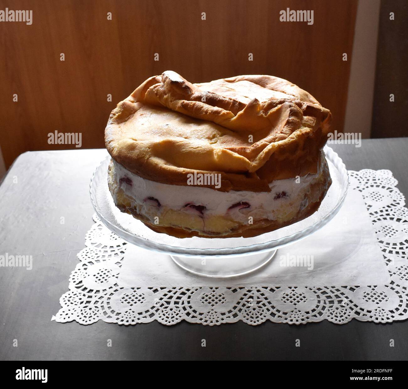 Beau et délicieux gâteau 'Carpaten' avec des fraises sur une assiette claire sur la table en bois avec milieu blanc. Banque D'Images