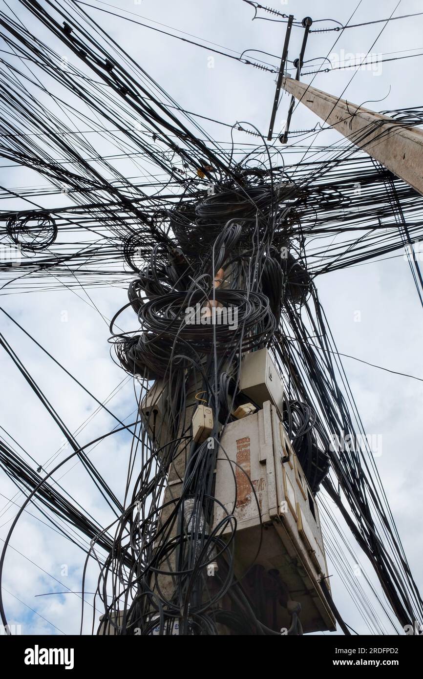 Image montrant une multitude considérable de câbles électriques entrelacés, représentant les réseaux électriques urbains désordonnés qui prévalent en Asie. Banque D'Images