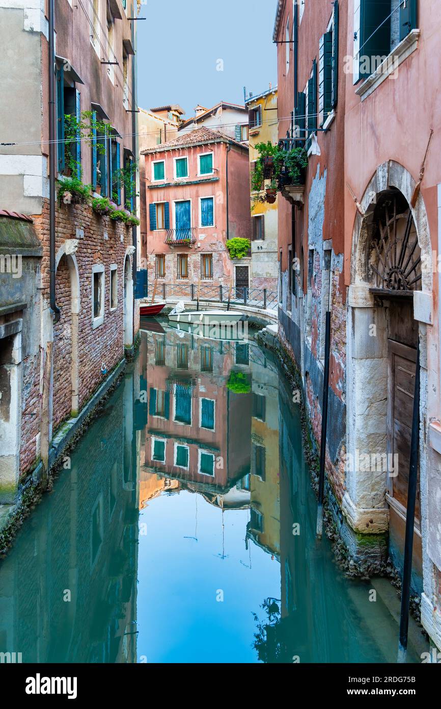 Canal d'eau étroit et brique rouge usés sur les buidings construits sur l'eau à Venise, Italie. Banque D'Images