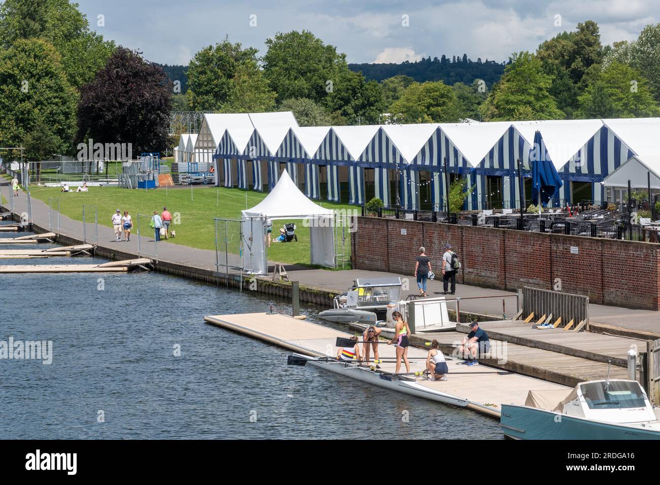 La Tamise à Henley-on-Thames avec les tentes de bateau bleues et blanches et les rameuses préparant leur bateau, Oxfordshire, Angleterre, Royaume-Uni Banque D'Images