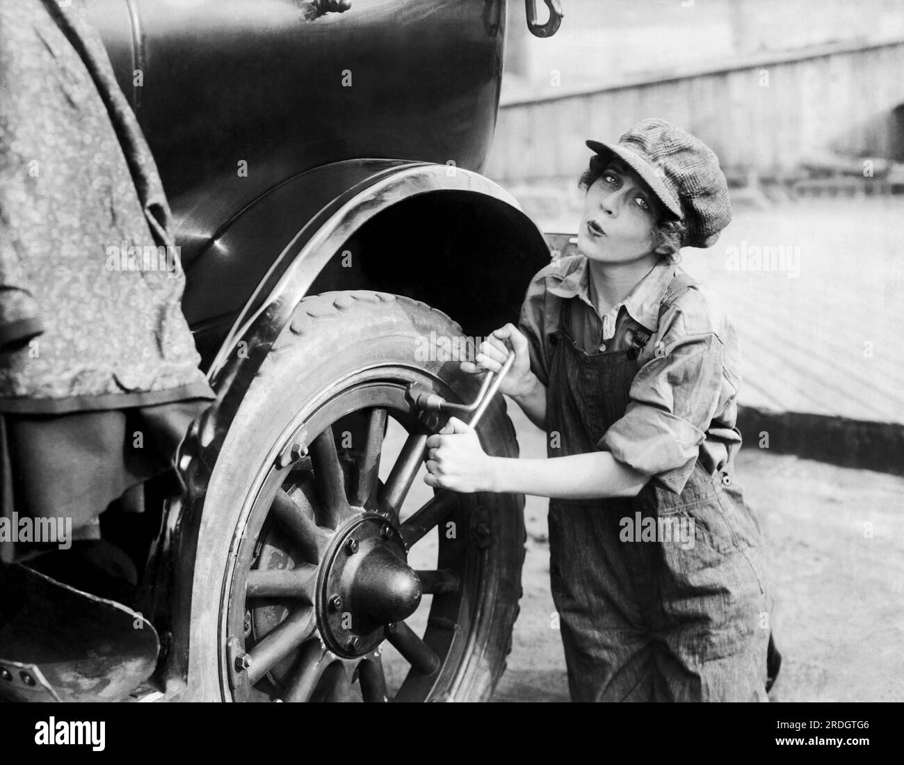 Hollywood, Californie : c. 1917 l'actrice June Caprice de Fox film travaille sur sa voiture. Banque D'Images