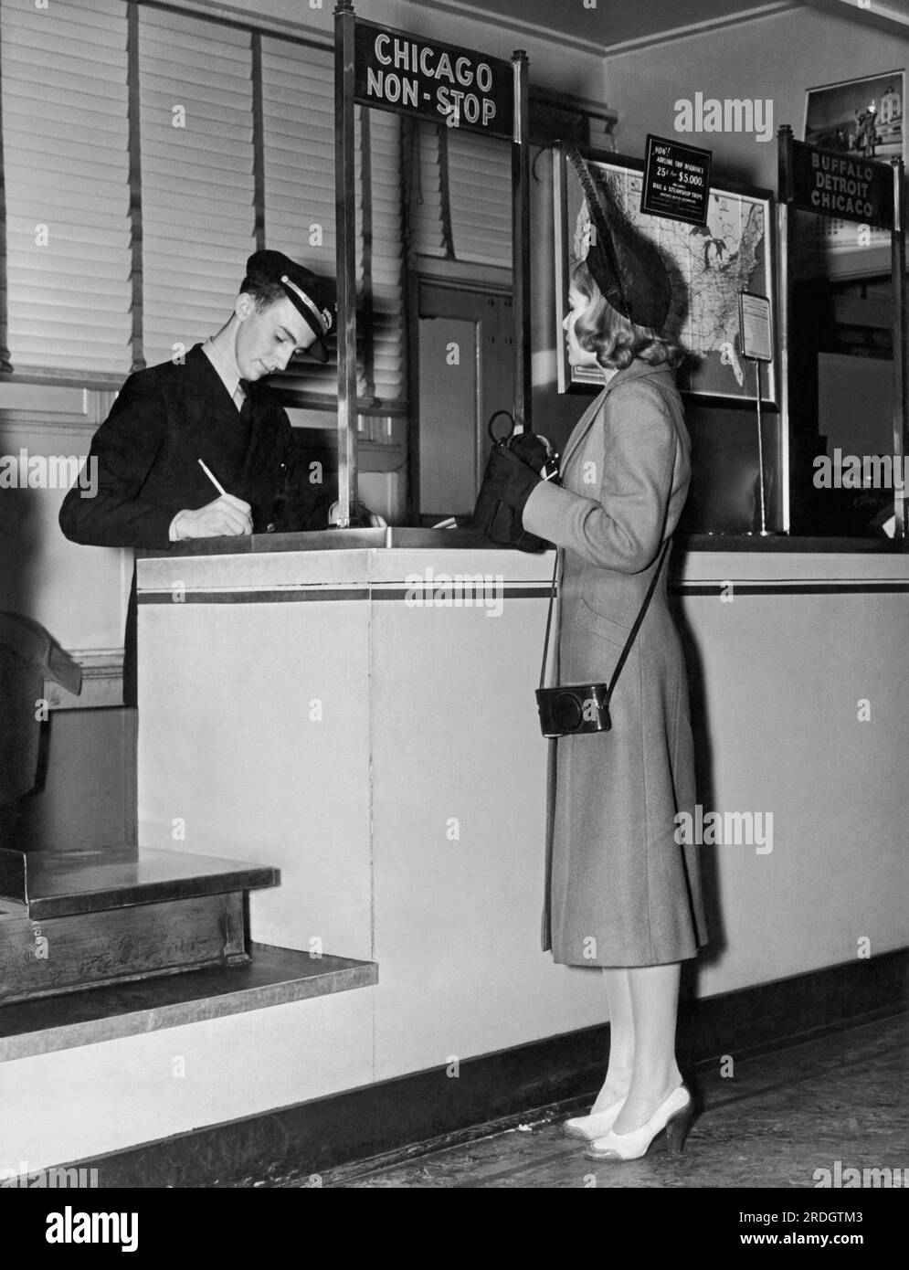 États-Unis : c. 1937 Une femme achète un billet direct pour Chicago sur American Airlines. Banque D'Images