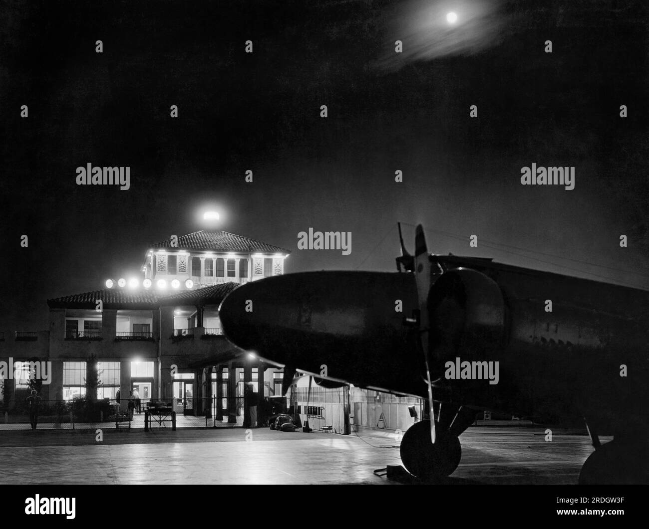 Burbank, Californie : c. 1934 Un nouvel avion bimoteur Boeing de 247 passagers devant le terminal de l'aéroport United la nuit. Banque D'Images