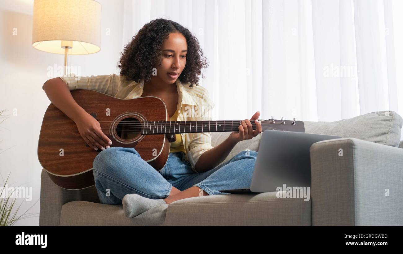 Leçon de guitare scolaire en ligne femme apprenant à distance Banque D'Images