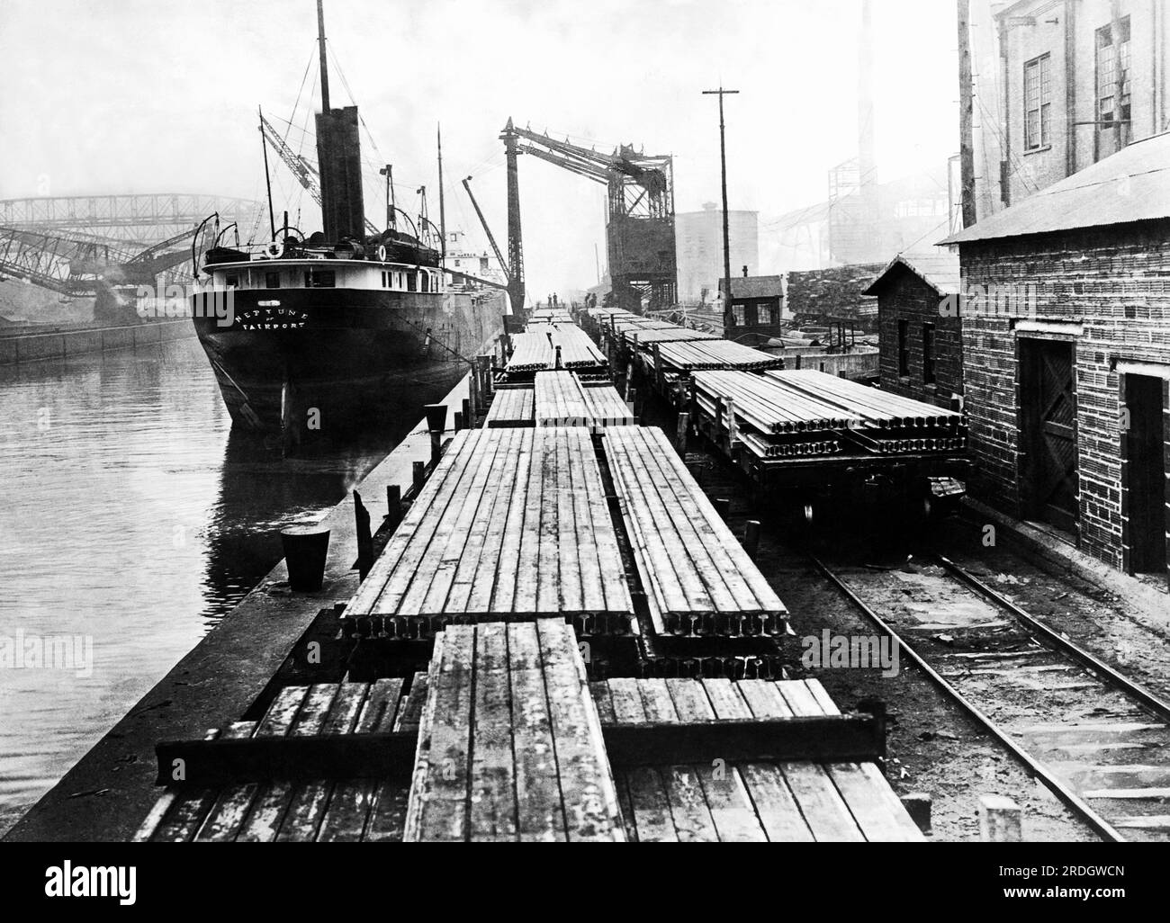 New York, New York c. 1912 le SS Neptune à côté de wagons plats chargés de voies rairoad sur les quais. Banque D'Images