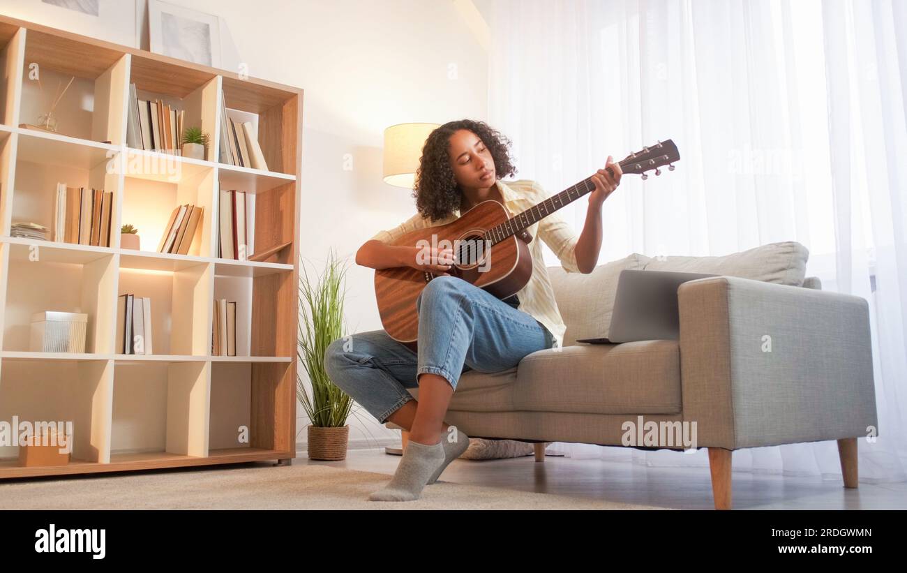 Guitare d'apprentissage de chanson jouant femme musicienne à la maison Banque D'Images