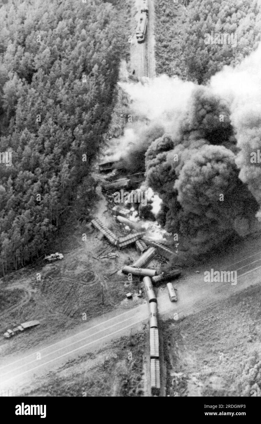 Houston, Alaska : 5 août 1972 près de 40 wagons chargés de carburant d'un train de marchandises de l'Alaska Railroad brûlent après une collision avec un camion-citerne vide. La partie réservoir du camion est visible sur la route à droite du train, tandis que la moitié cabine et remorque est à l'extrême gauche. Banque D'Images