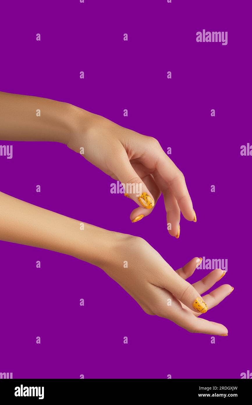 Des mains de femmes soignées avec un motif à ongles tendance sur fond violet Banque D'Images