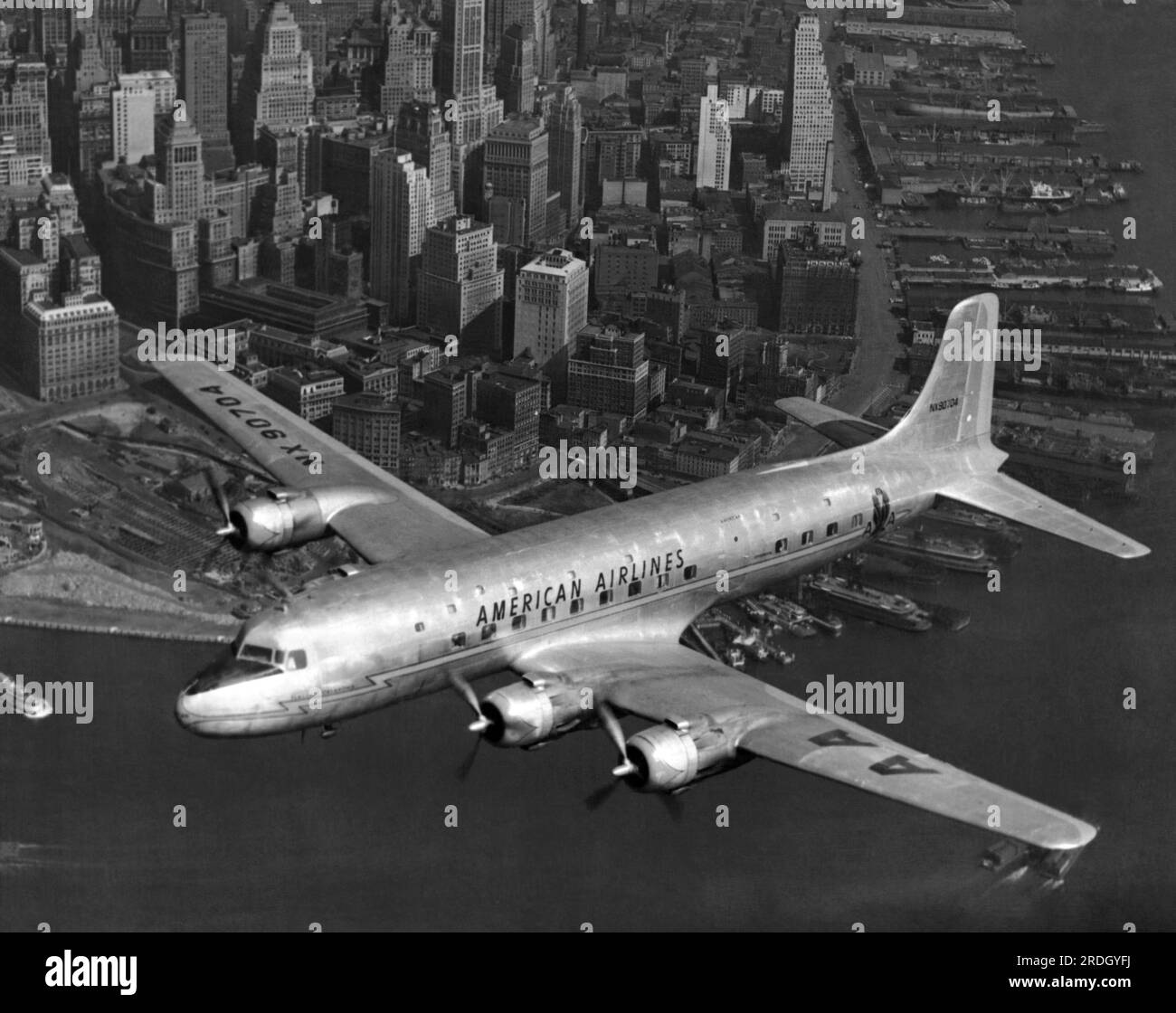 New York, New York : 1947 le DC-6 amiral d'American Airlines, 'Oklahoma', survolant New York. Banque D'Images