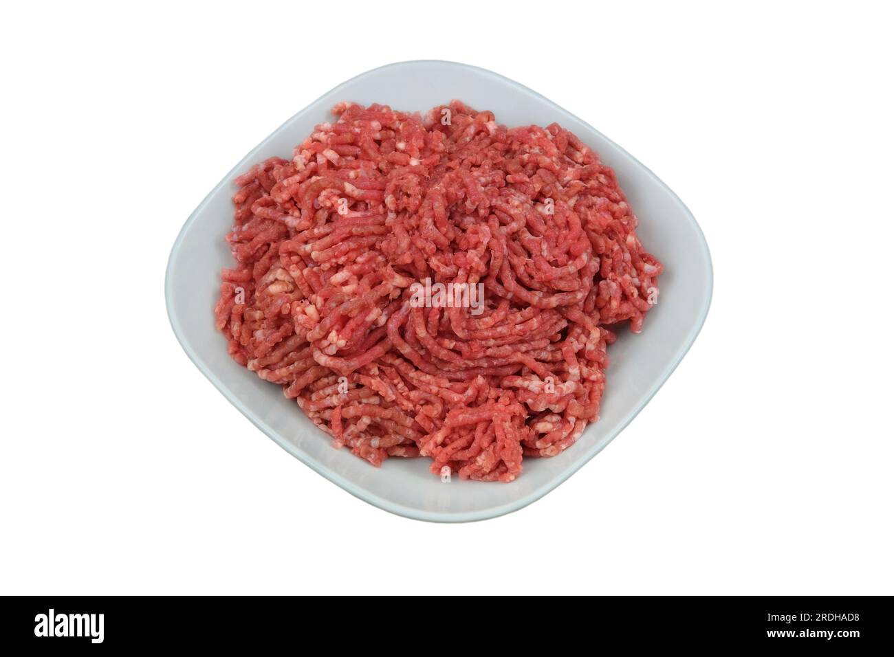 Bol de viande hachée isolé sur fond blanc. La viande hachée maison sort du hachoir à viande. Cuisiner un hamburger. Banque D'Images