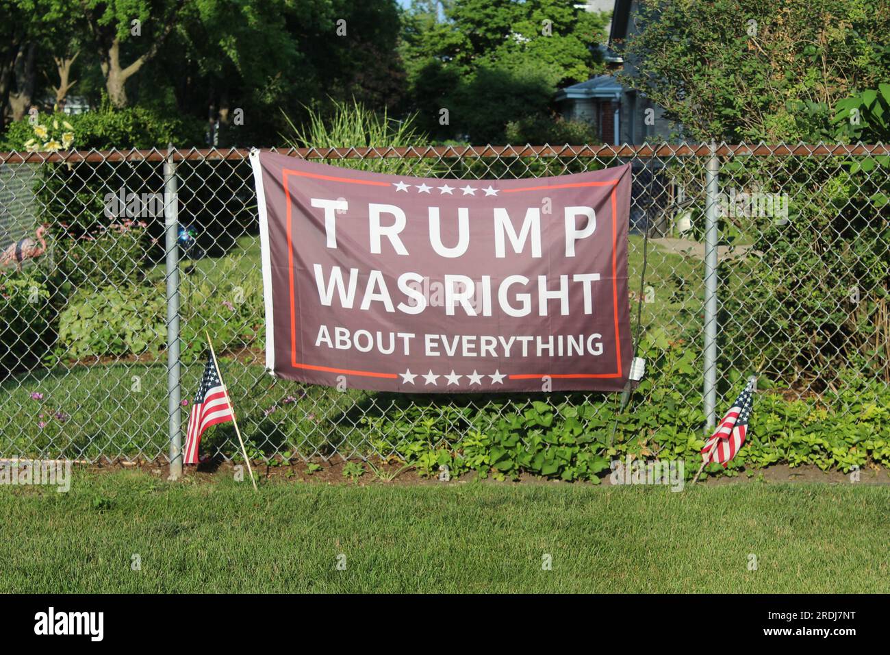 Trump avait raison à propos de tout drapeau sur une clôture avec fond vert luxuriant à des Plaines, Illinois Banque D'Images